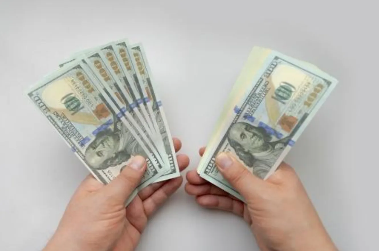 Hands holding cash representing additional injector income