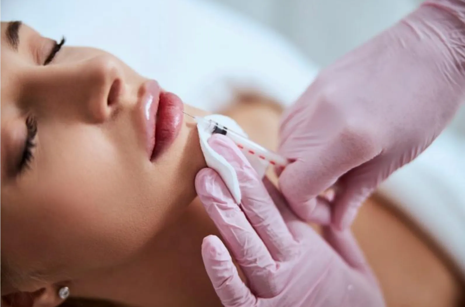 Close-up of an aesthetic injector performing a facial injection